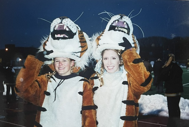 Two friends in tiger mascot costumes at a school event